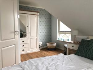 a bedroom with a bed and a dresser and a window at Kavelweg Haus JENNY in Zingst