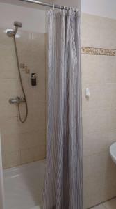 a shower with a striped shower curtain in a bathroom at Penzion TCV Pardubice in Pardubice