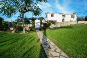 a grassy yard with a house and a tree at Villa Parets de Sucre in Les Cases d'Alcanar