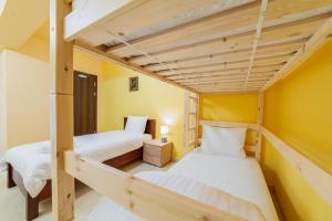 2 łóżka piętrowe w pokoju z żółtymi ścianami w obiekcie La Hacienda w mieście Vilvoorde