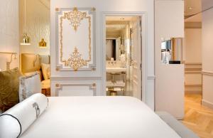 a bedroom with a white bed and a bathroom at Hotel Bowmann in Paris