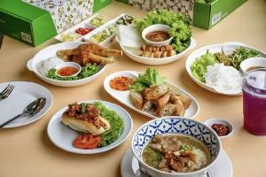 ein Tisch, der mit Tellern voller Essen bedeckt ist in der Unterkunft BJ city hotel in Surat Thani