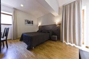 um quarto com uma cama e uma grande janela em Siena Gallery - Rooms Only em Siena