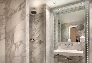 een badkamer met een wastafel en een spiegel bij Hotel Bowmann in Parijs