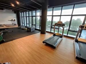 an empty gym with a treadmill in a room with windows at Timurbay Seafront Residences by Nature Home in Kuantan