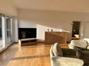 Una sala de estar con dos sillas y un televisor de pantalla plana. en Wiehengebirgs Fernblick App 4, en Bad Essen