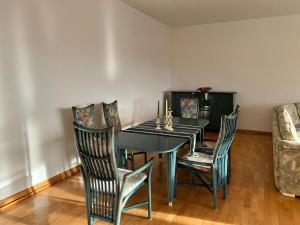 a dining room with a table and chairs and a couch at Wiehengebirgs Fernblick App 4 in Bad Essen