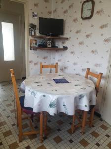 un tavolo da pranzo con 2 sedie e una TV di Chambre chaleureuse à la campagne a Marennes