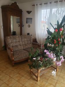 uma sala de estar com um sofá e uma mesa com flores em Chambre chaleureuse à la campagne em Marennes