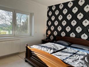 a bedroom with a bed with a black and white wall at Wiehengebirgs Fernblick App 4 in Bad Essen