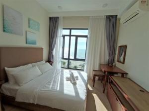 um quarto de hotel com uma cama e um piano em Timurbay Seafront Residences by Nature Home em Kuantan