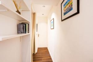 korytarz z białymi ścianami i drewnianą podłogą w obiekcie LE MAY AP4338 By Riviera Holiday Homes w mieście Villefranche-sur-Mer