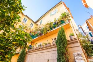 żółty dom z roślinami na płocie w obiekcie LE MAY AP4338 By Riviera Holiday Homes w mieście Villefranche-sur-Mer