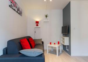 a living room with a blue couch and a tv at Sweet Home Dijon Nodot in Dijon