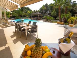 einen Tisch mit Obst und Gemüse auf einem Tisch neben einem Pool in der Unterkunft EL PARADISIO Splendid 5 STARS Villa atypical in Antibes with overflowing swiming pool in Antibes