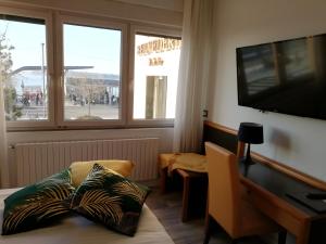 a room with a desk and a television and a table with pillows at Hotel Belvedere in Venice-Lido