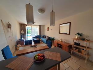 een woonkamer met een blauwe bank en een tafel bij KALIAKRIA RESORT AP. 95 in Topola