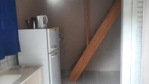 eine kleine Küche mit einem weißen Kühlschrank und einem Holzbalken in der Unterkunft CardónApart in Puerto Iguazú