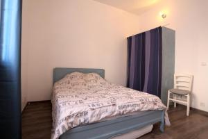 - une petite chambre avec un lit et une chaise dans l'établissement appartement centre frontignan, à Frontignan