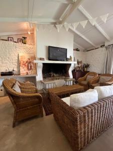 a living room with wicker furniture and a fireplace at The Stables in Protem