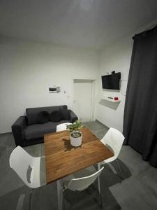 - un salon avec une table en bois et des chaises blanches dans l'établissement Malta Suites, à Isla