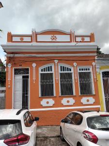 dois carros estacionados em frente a um edifício em Hostel Nossa Sra de Lourdes em Salvador