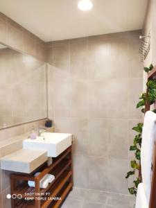 La salle de bains est pourvue d'un lavabo et d'un miroir. dans l'établissement Timurbay Seafront Residences by Nature Home, à Kuantan