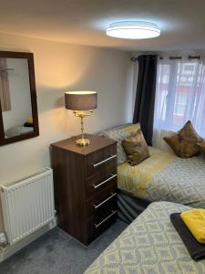a bedroom with two beds and a lamp on a dresser at THE MOUNTAIN VIEW SUITE - 2 minute walk to the lovely beach front promernade of llandudno in Llandudno