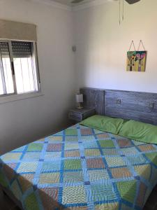 1 dormitorio con 1 cama con edredón en Alquimia, en Sauce de Portezuelo