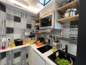 a kitchen with a sink and a counter top at Studio tout équipé à Nation Paris XI-Tout confort in Paris