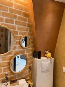 La salle de bains est pourvue d'un lavabo et d'un mur en briques. dans l'établissement Studio tout équipé à Nation Paris XI-Tout confort, à Paris