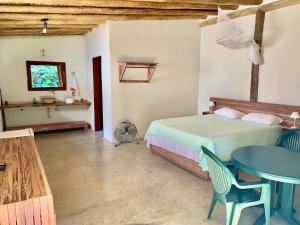um quarto com uma cama, uma mesa e cadeiras em Prumirim Camping & Chalés em Ubatuba