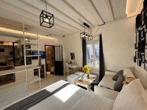 a bedroom with a white bed and a living room at Studio tout équipé à Nation Paris XI-Tout confort in Paris