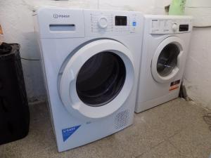 Una lavadora y secadora blancas en una habitación en Albergue de São Bento, en Caminha