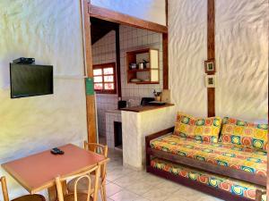 uma sala de estar com um sofá e uma mesa em Prumirim Camping & Chalés em Ubatuba