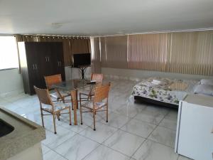 un soggiorno con tavolo, sedie e letto di Uba Apart imóveis a Ubá