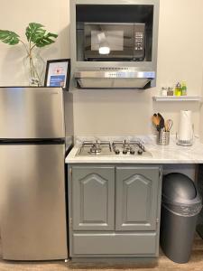 a kitchen with a stainless steel stove and a microwave at Bonito departamento remodelado tranquilo y centrico in Ciudad Juárez