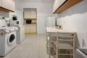 une cuisine avec un lave-linge et une table avec des chaises dans l'établissement Casa Paola, à Levanto