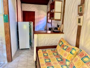 uma pequena cozinha com um sofá e um frigorífico em Prumirim Camping & Chalés em Ubatuba