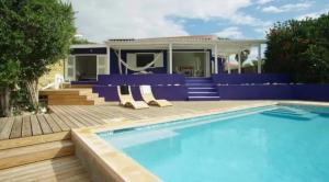 a swimming pool with chairs next to a house at Idyllic Curacao Home with Stunning Views in Willemstad