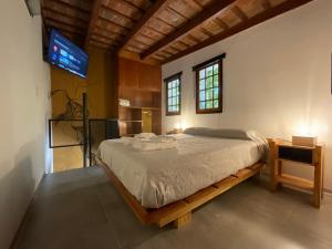 1 dormitorio con 1 cama y TV en la pared en Encantador Duplex cerca de todo en Córdoba