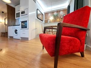 een woonkamer met een rode stoel en een tafel bij JARDÍN CENTRO in Zamora