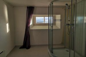 La salle de bains est pourvue d'une douche et d'une fenêtre. dans l'établissement Tranøy Fyr, à Tranøya