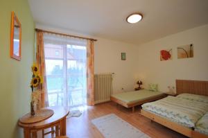 a bedroom with a bed and a table and a window at Katka a Martin samostatný apartmán s vlastným vchodom in Liptovský Mikuláš