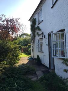 una casa blanca con una puerta y un patio en Idyllic Stratford upon Avon cottage en Shottery
