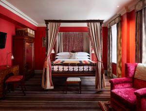 a bedroom with red walls and a bed with a canopy at The Zetter Clerkenwell in London