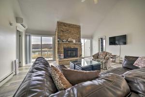ein Wohnzimmer mit einem Ledersofa und einem Kamin in der Unterkunft Alpine Lake Resort Home Stunning Lake Views! in Terra Alta