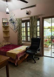 a bedroom with a bed and a desk and a chair at Homestay - Heaven Aumgarden in Trivandrum