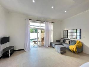 a living room with a couch and a tv at Inviting 1-Bed Studio in Dar es Salaam in Dar es Salaam