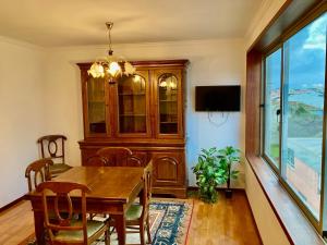 uma sala de jantar com uma mesa de madeira e uma televisão em Povoa Center Beach Apartment na Póvoa do Varzim